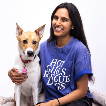 Woman wearing a blue t-shirt with 'Hot Girls Rescue Dogs' text, sitting with a dog on a white background
