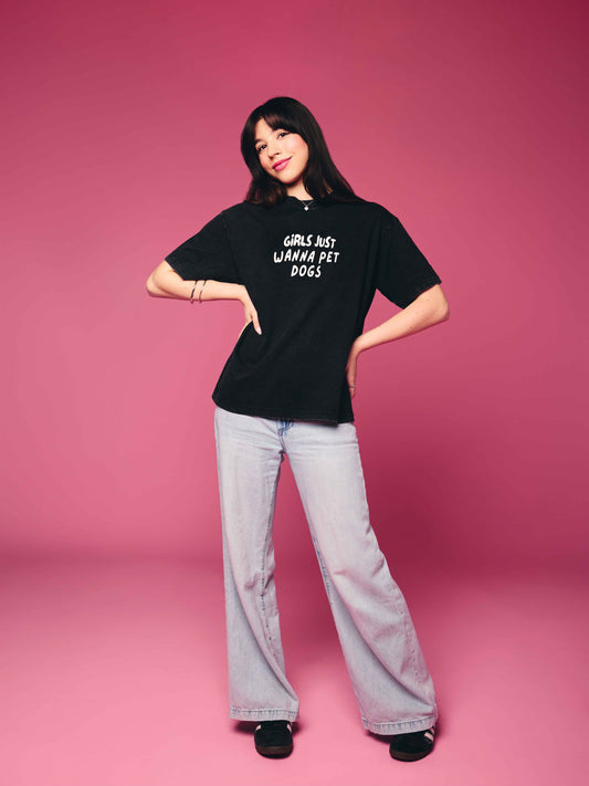 Person wearing a black t-shirt with text on a pink background