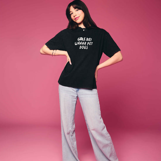 Person wearing a black t-shirt with text on a pink background