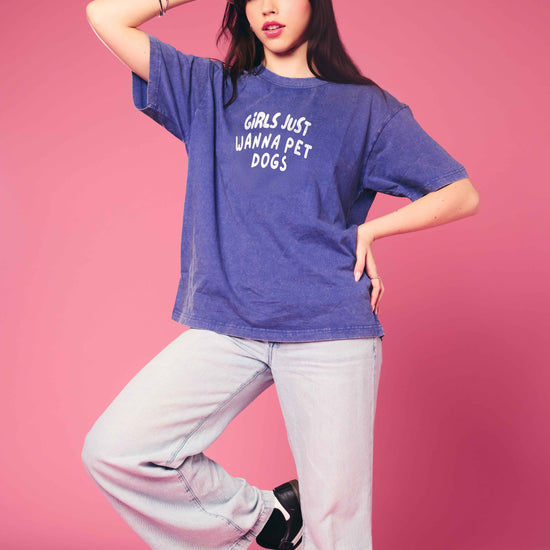 Person wearing a blue t-shirt with text on a pink background